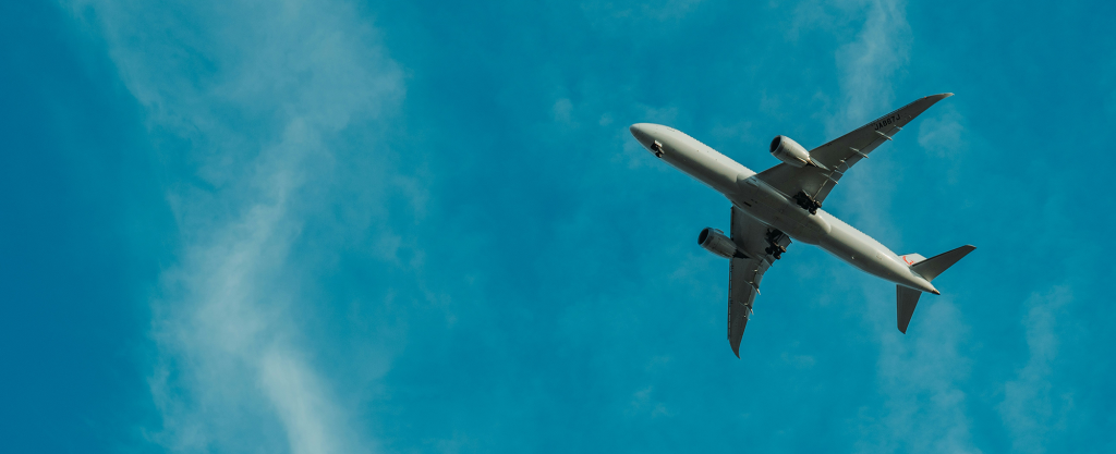 Cómo volar en business barato. Imagen de un avión surcando el cielo.